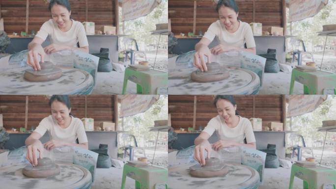 亚洲女性黏土艺术家在她的工作室里工作，用旋转的陶轮。可持续发展生活方式