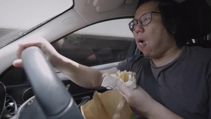 开车时吃汉堡的人。