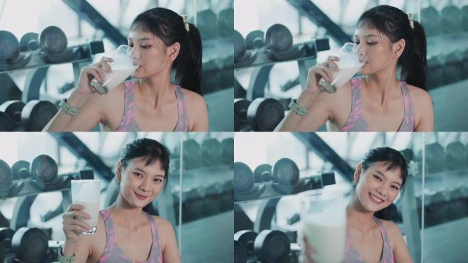 迷人的健身亚洲妇女完成锻炼和喝蛋白质牛奶奶昔维生素训练后。健美。健康的生活方式。