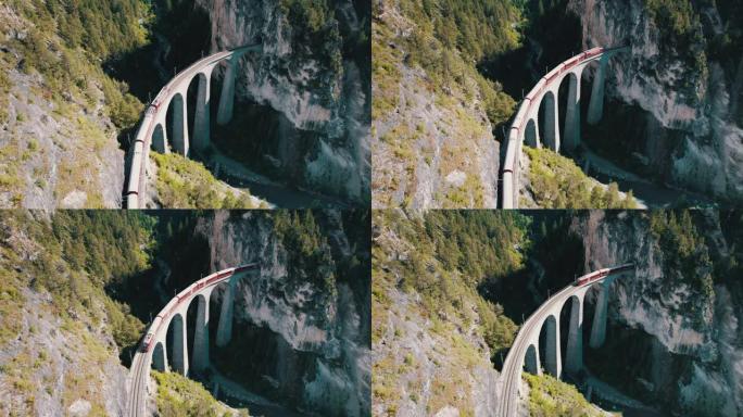 沿着瑞士阿尔卑斯山的Landwasser高架桥行驶的红色火车的鸟瞰图