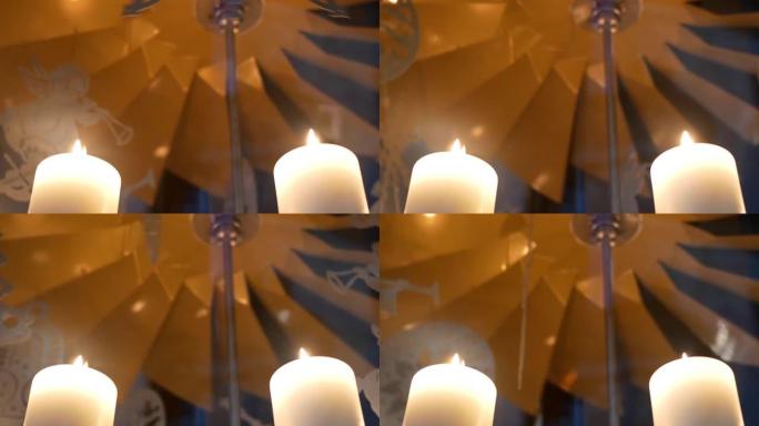 降临节白色蜡烛上的旋转装饰由胶合板制成，描绘天使或圣诞树