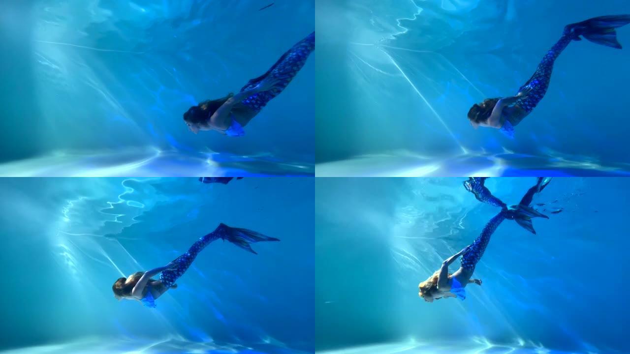 美人鱼尾巴的女人在水下游泳和潜水。