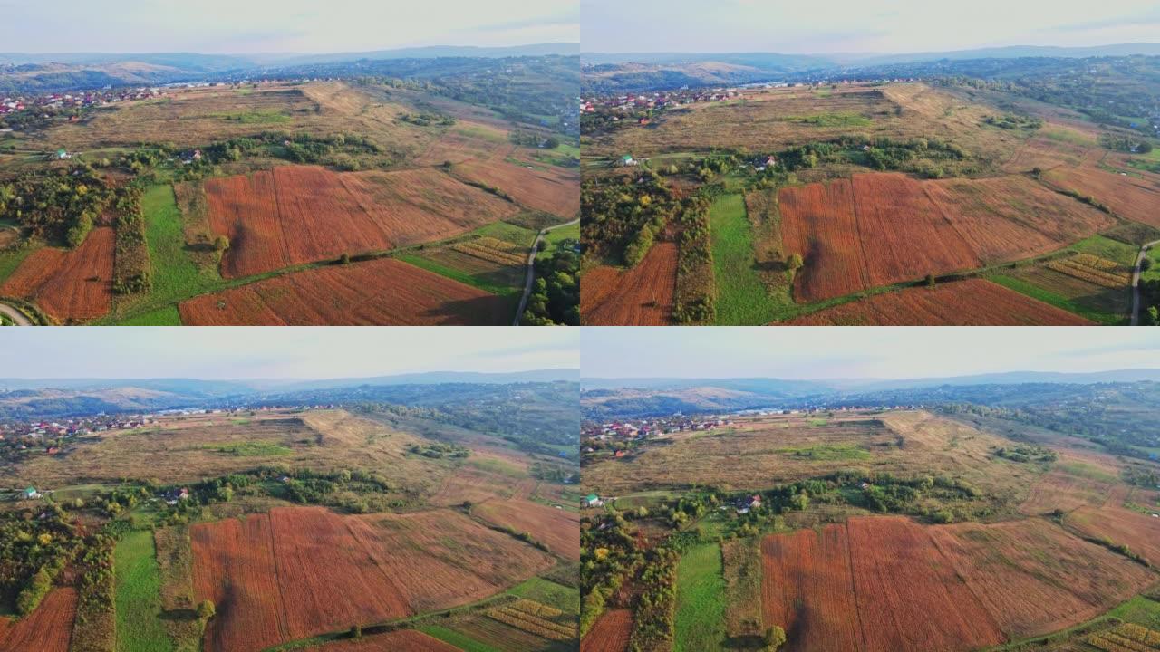 乌克兰的田野在定居点附近的山丘上延伸鸟瞰图