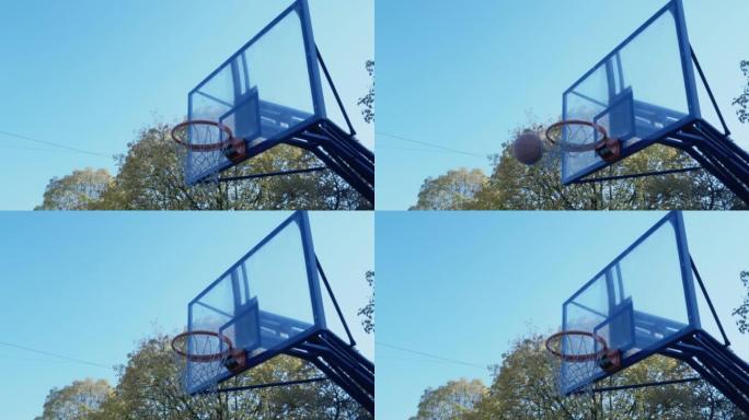 篮球球击中篮板，反弹，进入篮筐并撕开球网。低角度侧视图，复制空间