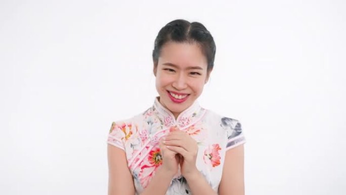 中国/亚洲妇女表示敬意，在春节期间以白色背景表示感谢，穿着旗袍白色碎花连衣裙