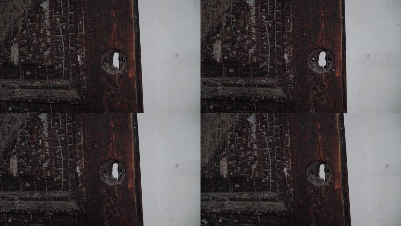 纵火和房屋大火后，旧烧焦的门中的空黑钥匙孔。