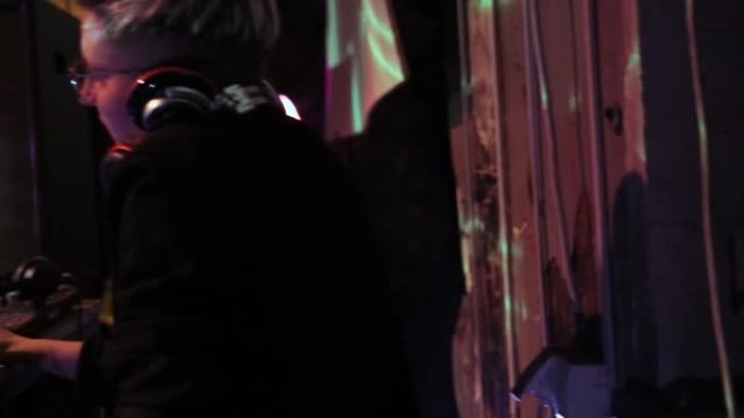 控制台上的DJ在夜舞俱乐部中混合音乐