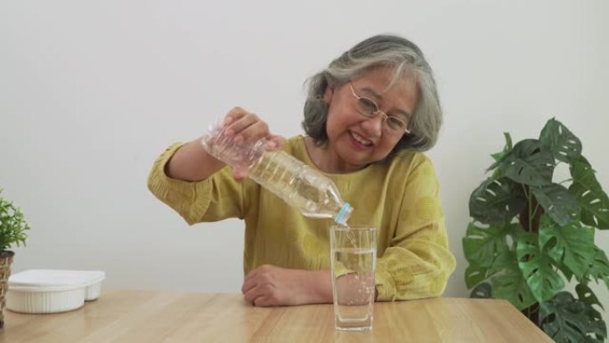 快乐的亚洲老年妇女从瓶子里喝水，身体健康。身体健康，生活方式。