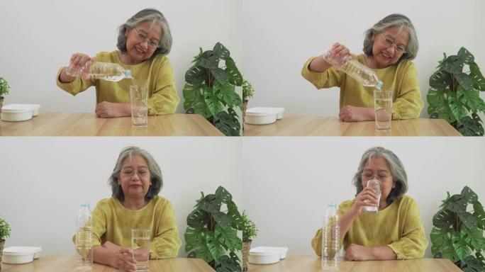快乐的亚洲老年妇女从瓶子里喝水，身体健康。身体健康，生活方式。