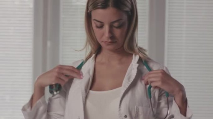 年轻女医生将听诊器戴在脖子上的前视图
