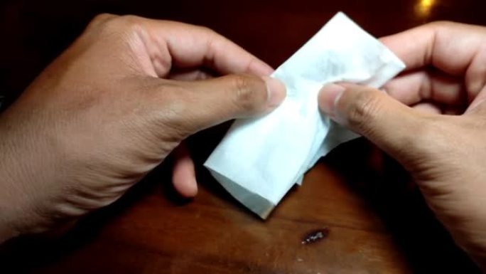 一名男子将纸巾折叠成小尺寸
