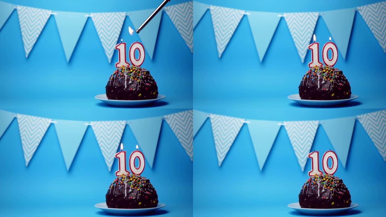 巧克力生日蛋糕，蓝色背景上燃烧着10号，10号蜡烛。复制空间。文本的位置