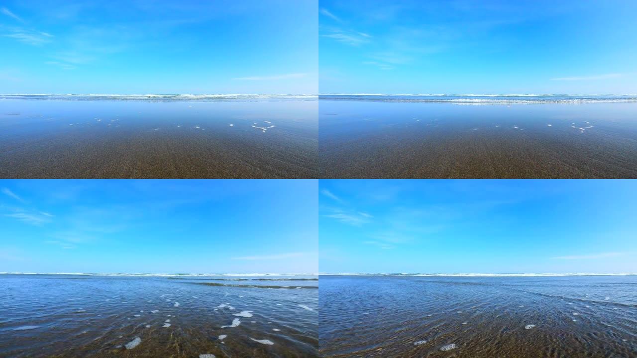 在海滩上飞溅波浪。海浪溅起相机
