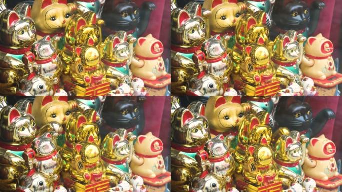 商店陈列的多个传统日本maneki neko召唤猫移动爪子小雕像，一组物品，商店出售的旅游纪念品，展