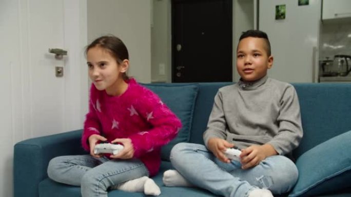 在室内玩电子游戏的多种族儿童的移动镜头