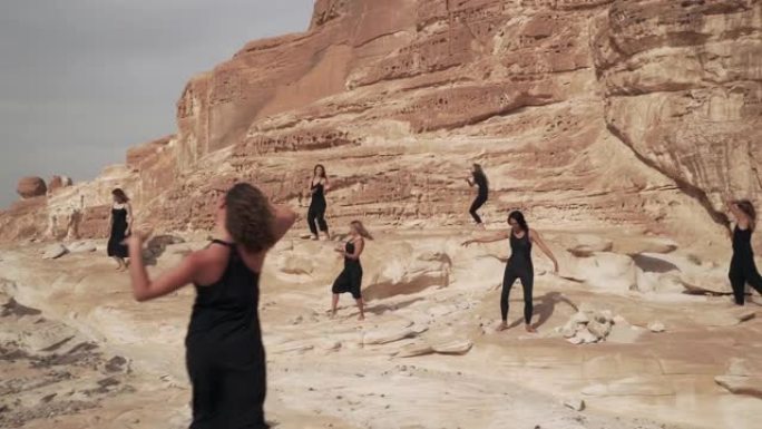 沙漠峡谷中，身着黑衣的妇女在练习狂喜的舞蹈