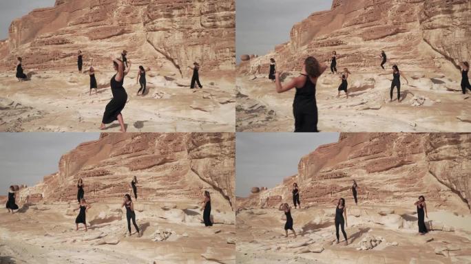 沙漠峡谷中，身着黑衣的妇女在练习狂喜的舞蹈