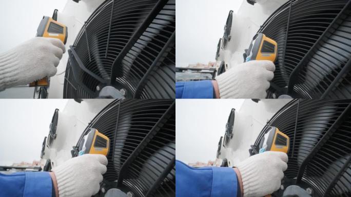 技术人员使用热成像红外温度计检查冷凝单元热交换器