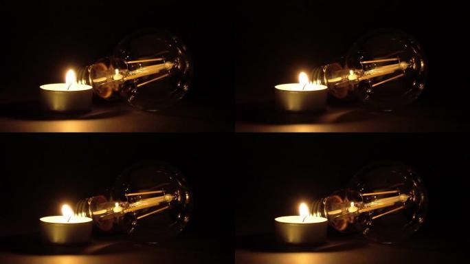 发光二极管灯泡旁边点燃的一根茶灯蜡烛