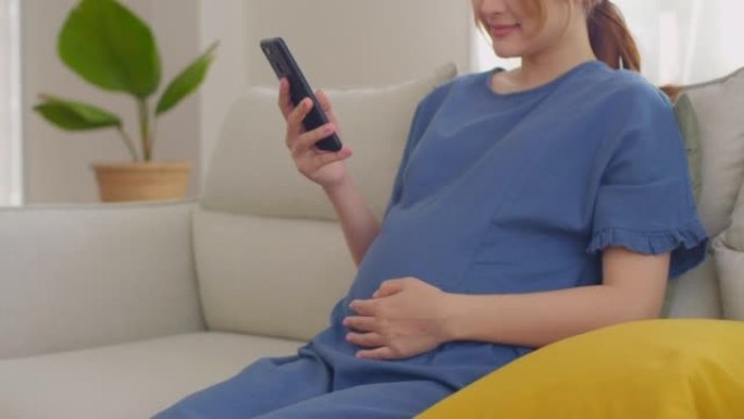 年轻孕妇手拿手机看视频通话