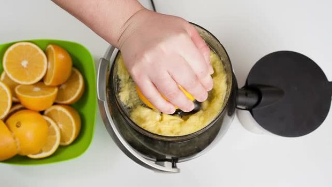 女人用榨汁机手工制作橙汁