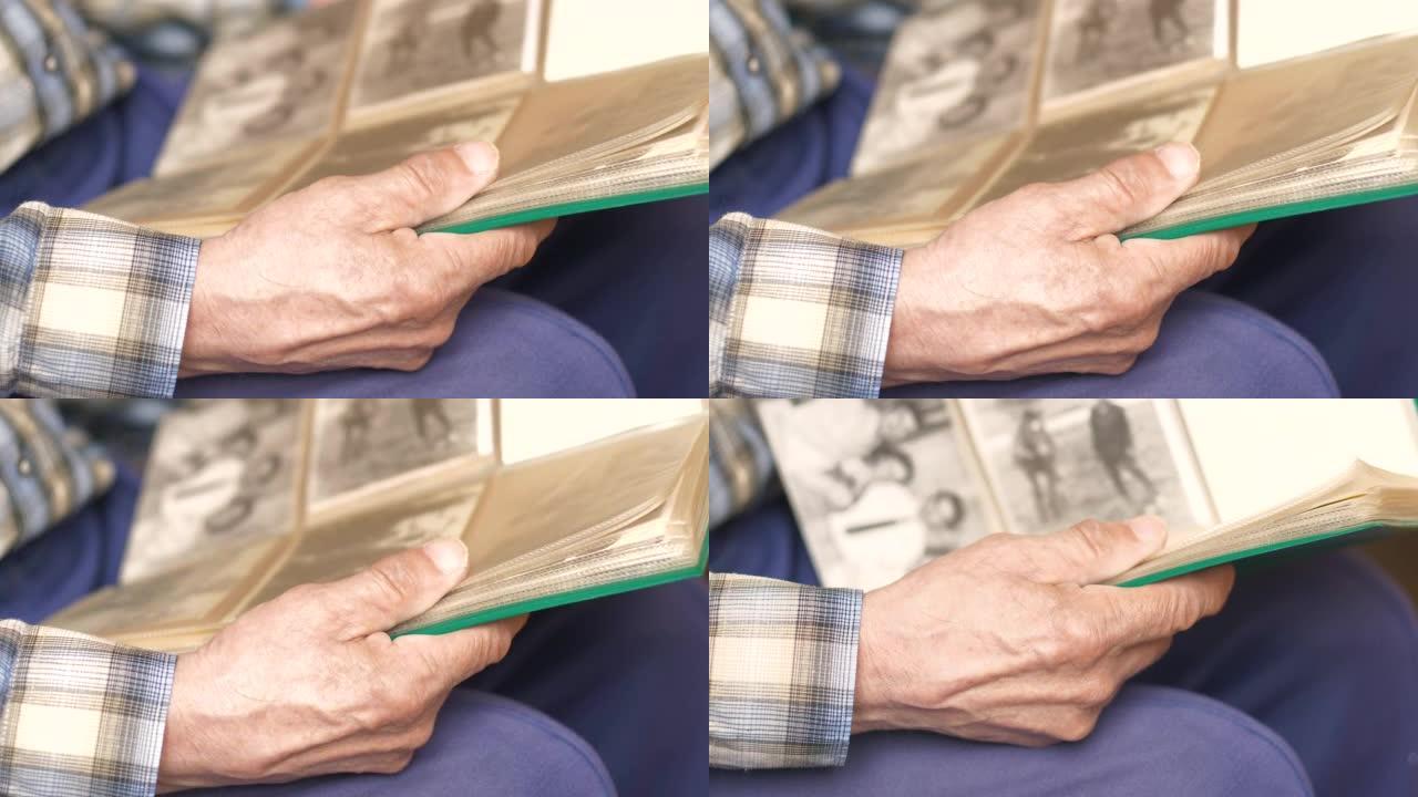 一个老人手中的家庭相册的特写。养老金领取者翻阅相册，回忆和怀旧主题的页面。选择性聚焦。旧全家福