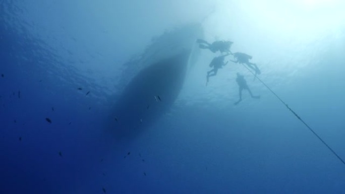 水肺潜水员上升的水面回到船上，在水下用太阳光束和光线固定锚线海洋风景