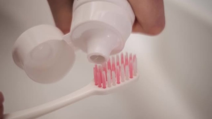 将牙膏挤在牙刷上的手