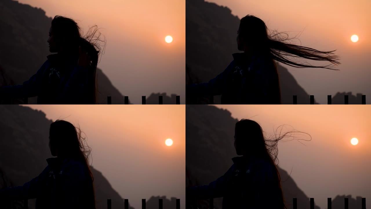 快乐的印度女人在山上享受日出的剪影。在印度古吉拉特邦Girnar hills。人和日出天空。旅行和假