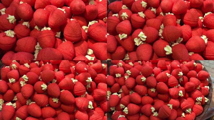 柜台上的草莓果冻糖果摆放着彩虹的所有颜色，就像唾液从果冻雕像流向意大利面和巧克力一样多