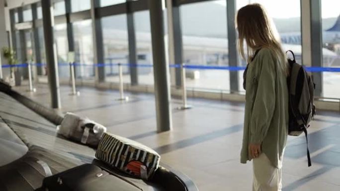 在机场等候行李传送带旁的旅行女