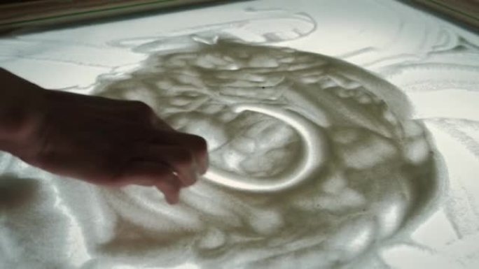女人的手在沙心上画。慢动作