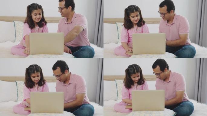 印度父亲在女儿的在线会议期间帮助女儿，并在卧室使用笔记本电脑。