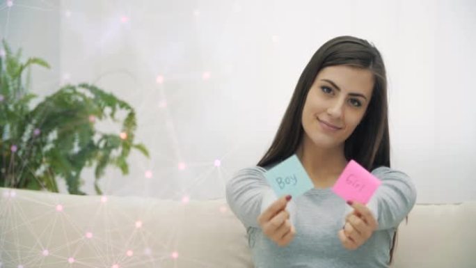 4k慢动作视频，孕妇拿着粉红色和蓝色的纸，这意味着未来婴儿的性别。