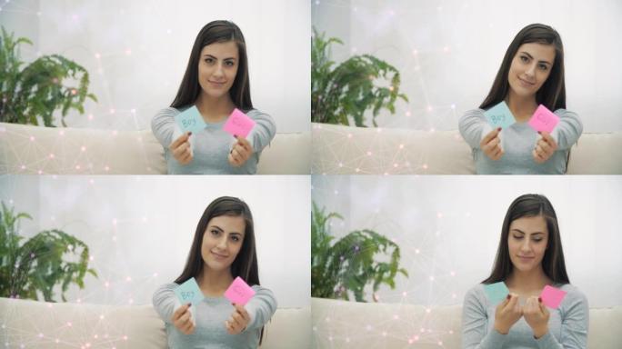 4k慢动作视频，孕妇拿着粉红色和蓝色的纸，这意味着未来婴儿的性别。