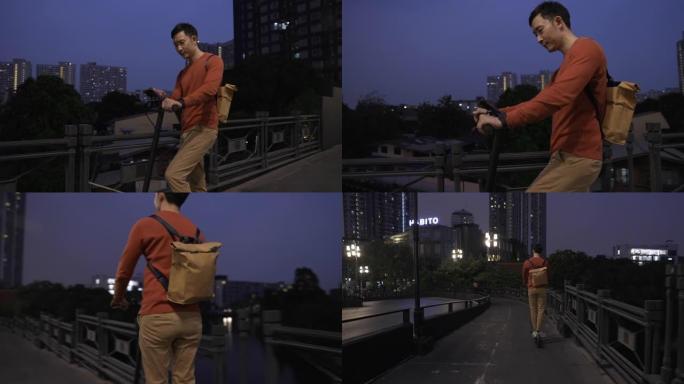 夜间生活方式亚洲男子骑电动推踏板车过桥