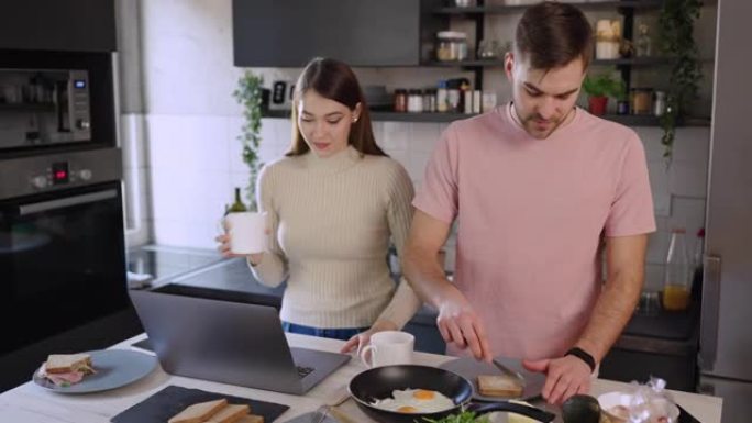年轻夫妇在家工作时在厨房吃早餐