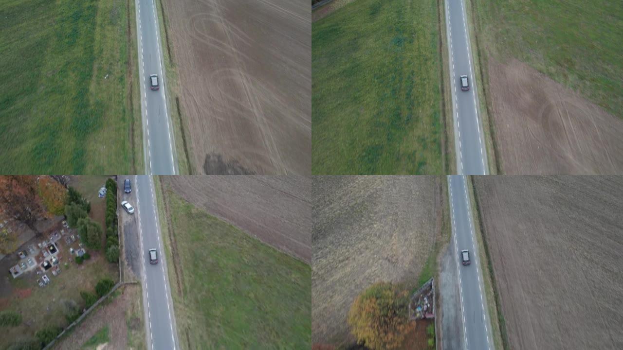 汽车正在田野中行驶，从无人机上拍摄了鸟瞰图。秋天的时候在柏油路上，摄像机跟随汽车。