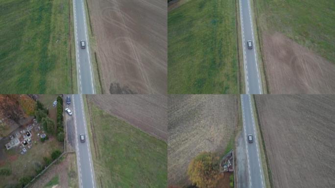 汽车正在田野中行驶，从无人机上拍摄了鸟瞰图。秋天的时候在柏油路上，摄像机跟随汽车。