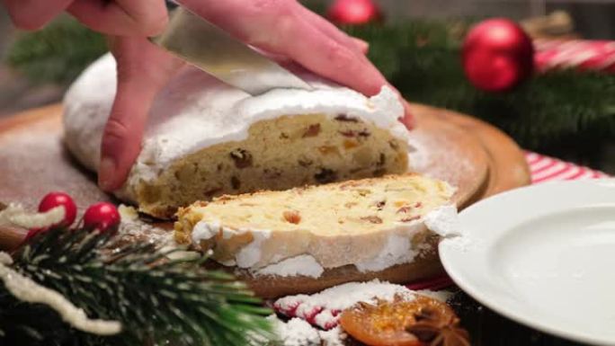 女人用杏仁饼和干果切成传统的圣诞蛋糕