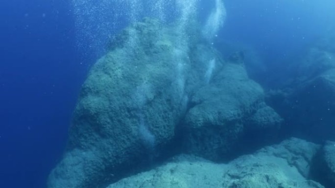 水下接近地面，天空可以看到海洋风景太阳光线和气泡缓慢放松的海洋背景