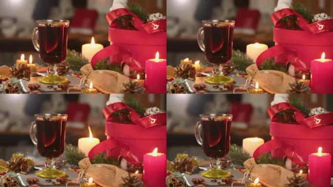 玻璃杯、谷胱甘肽和肉桂特写热酒。甜红葡萄酒配八角茴香，装饰松果，吹蜡烛。传统的冬季饮料。圣诞假期和新