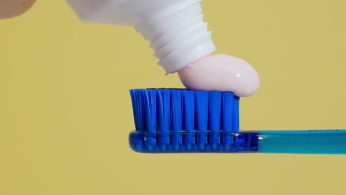 牙刷上有卫生概念，特写。刷牙的概念。黄色背景