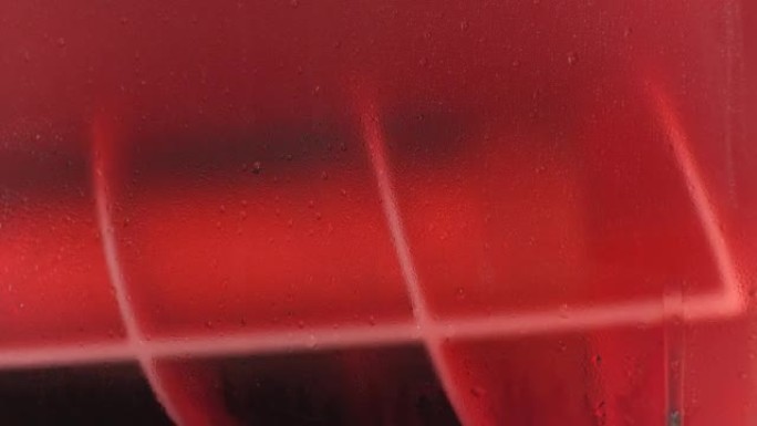 冰草莓果汁压碎机内部旋转，特写细节，玻璃墙上的水滴
