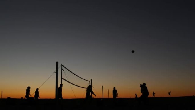 日落时沙滩球场上的排球网剪影，加利福尼亚海岸的球员。