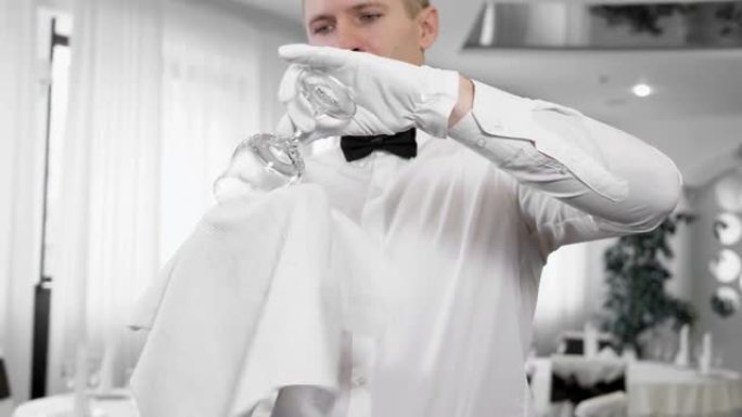 一名戴着白手套的男服务员擦着酒杯
