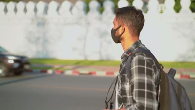 年轻人戴着防护口罩咳嗽新型冠状病毒肺炎冠状病毒感染大流行疾病病毒，男性游客步行步行街景点，流行空气健