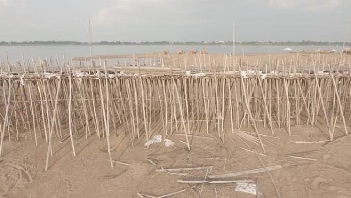 无人驾驶飞机在沙洲上竖立的竹桥上升起