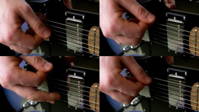 男吉他手在蓝色电吉他上用拨子弹指。