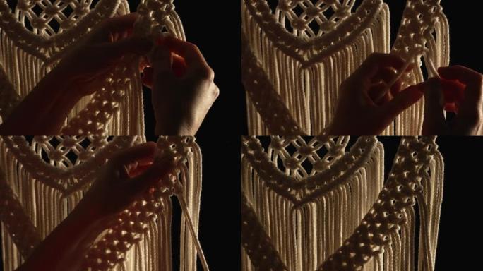 用天然白色棉线编织花边图案。女性的手编织结在黑色背景上创造蕾丝装饰。车间、纺织工艺品的创意过程。特写